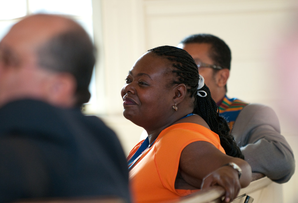 woman smiles in pew during ministry service