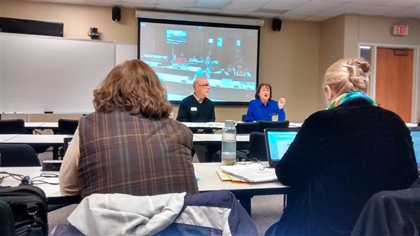 Brent Messick and Kelly Williams speak in front of classroom of students about church finances