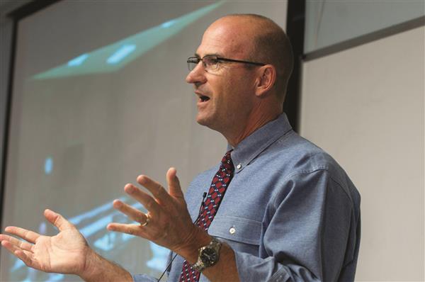 Dr. Mike Graves speaks at the front of a classroom