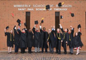 Saint Paul School of Theology Oklahoma Campus graduates throwing caps at commencement.