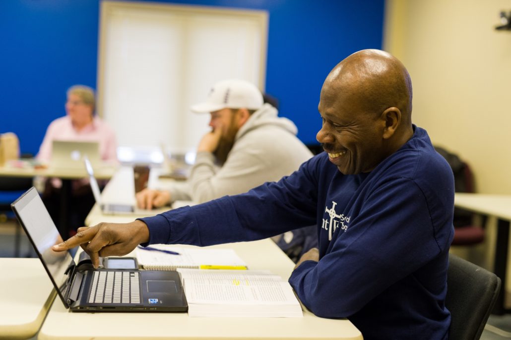 Student on laptop experiencing online theological studies at Saint Paul School of Theology.