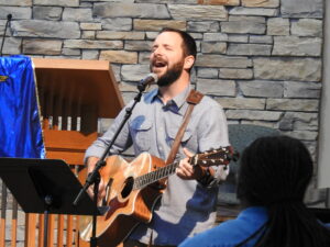Music minister playing guitar in worship