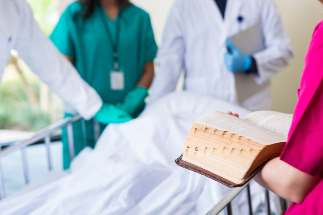 Chaplain reading scripture in patient room