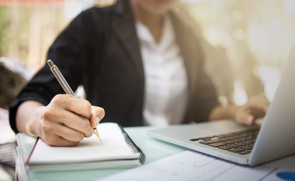 Female graduate student writing notes in a notebook